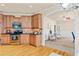 Well-lit kitchen with wooden cabinetry, stainless steel appliances, and seamless arched access to living area at 5233 Greymoss Ln, Apex, NC 27539