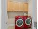 Laundry room featuring red washer and dryer, and upper cabinets for storage at 5233 Greymoss Ln, Apex, NC 27539