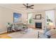 Bright living room featuring a fireplace, ceiling fan, and stylish furnishings at 5233 Greymoss Ln, Apex, NC 27539