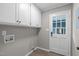 Well-organized laundry room with cabinets and exterior door, offering convenience and functionality at 5804 Heathill Ct, Raleigh, NC 27603