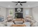 Inviting living room featuring a painted brick fireplace, modern furniture, and bright natural light at 5804 Heathill Ct, Raleigh, NC 27603