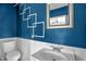 Bathroom features blue walls, white wainscoting, white fixtures, and an ornate mirror at 5805 Craig Rd, Durham, NC 27712