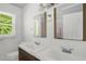 Bright bathroom featuring double vanity, a window, and clean white beadboard paneling at 5805 Craig Rd, Durham, NC 27712