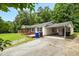 View of the home's driveway, carport, storage, and combination brick and vinyl siding at 5805 Craig Rd, Durham, NC 27712