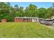 Home featuring brick and white siding, green lawn, mature trees, and a gray vehicle in the driveway at 5805 Craig Rd, Durham, NC 27712