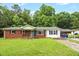 Charming single-story home with a brick facade, bright turquoise front door, and a lovely front yard at 5805 Craig Rd, Durham, NC 27712