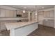 Open kitchen with grey cabinets, granite countertops, and a large island, perfect for entertaining at 61 Merrifield Ln, Garner, NC 27529