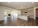 Open-concept kitchen with granite countertops and large island flows into spacious living area with fireplace at 61 Merrifield Ln, Garner, NC 27529