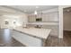 Modern kitchen with gray cabinets, granite countertops, and a large island with a stainless steel sink at 61 Merrifield Ln, Garner, NC 27529