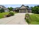 Beautiful home with a three-car garage, stone accents, well-manicured lawn, and mature landscaping at 67 Marshlane Way, Clayton, NC 27527