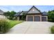 Charming home featuring a three-car garage, stone detailing, and a meticulously maintained front lawn at 67 Marshlane Way, Clayton, NC 27527