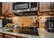Modern cooktop with sleek finishes and stainless steel appliances make cooking a delight at 67 Marshlane Way, Clayton, NC 27527