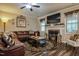Cozy living room with a fireplace, hardwood floors, and comfortable leather sectional at 67 Marshlane Way, Clayton, NC 27527