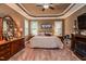 Large main bedroom with tray ceilings, neutral tones, a sitting area, and carpeted floors at 67 Marshlane Way, Clayton, NC 27527