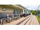 Relax outdoors with comfortable patio seating and shade under umbrellas near the tennis courts at 67 Marshlane Way, Clayton, NC 27527
