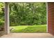 Covered back porch offers a serene view of the backyard lawn and surrounding woods at 740 Treviso Ln, Apex, NC 27502