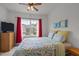 Comfortable bedroom with a patterned bedspread, bright window with red curtains, and ceiling fan at 740 Treviso Ln, Apex, NC 27502