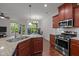 Open-concept kitchen with granite counters, wood cabinetry, and stainless appliances at 740 Treviso Ln, Apex, NC 27502