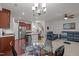 Open-concept living room with modern chandelier, kitchen, staircase, and comfortable blue seating area at 740 Treviso Ln, Apex, NC 27502