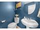 Stylish half bathroom featuring a pedestal sink, toilet, and blue accent wall at 76 Haywood St, Spring Lake, NC 28390