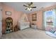 Bedroom features a light pink color scheme, neutral carpeting, and a charming window view at 76 Haywood St, Spring Lake, NC 28390