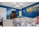 A bedroom featuring blue walls, a ceiling fan, and race-themed decor creating a youthful atmosphere at 76 Haywood St, Spring Lake, NC 28390