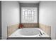 Close up of jetted tub with a decorative stained-glass window at 76 Haywood St, Spring Lake, NC 28390