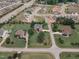 Aerial perspective featuring a brick home amidst a residential area with mature trees, lawns, and nearby community amenities at 7800 Twin Pines Way, Fuquay Varina, NC 27526