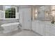 Stylish bathroom featuring a soaking tub, a view, and double sinks at 7800 Twin Pines Way, Fuquay Varina, NC 27526