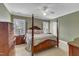 Spacious bedroom with a four-poster bed, large windows, and traditional decor at 7800 Twin Pines Way, Fuquay Varina, NC 27526