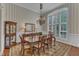 Traditional dining room with striped walls, an elegant chandelier and large windows with plantation shutters at 7800 Twin Pines Way, Fuquay Varina, NC 27526