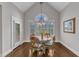 Bright dining room featuring a round wood table, chandelier, and views through large windows at 7800 Twin Pines Way, Fuquay Varina, NC 27526