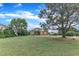 Inviting brick home surrounded by lush greenery, with a well-maintained lawn and picturesque sky at 7800 Twin Pines Way, Fuquay Varina, NC 27526