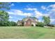 Beautiful brick home with mature trees, offering a serene and private setting under a clear blue sky at 7800 Twin Pines Way, Fuquay Varina, NC 27526