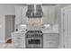 Kitchen features a stainless steel gas range, white cabinets, and marble countertops at 7800 Twin Pines Way, Fuquay Varina, NC 27526
