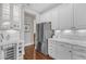 Kitchen features white cabinets, marble countertops, a wine cooler, and stainless steel refrigerator at 7800 Twin Pines Way, Fuquay Varina, NC 27526