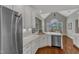 Bright kitchen featuring white cabinets, stainless steel refrigerator, and marble countertops at 7800 Twin Pines Way, Fuquay Varina, NC 27526