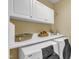 Functional laundry room with a large countertop, cabinets, and modern appliances at 7800 Twin Pines Way, Fuquay Varina, NC 27526