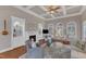 Inviting living room featuring a fireplace with built-ins, hardwood floors, coffered ceiling, and arched windows at 7800 Twin Pines Way, Fuquay Varina, NC 27526