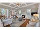 Spacious living room with a fireplace, built-in shelving, hardwood floors, and access to other rooms at 7800 Twin Pines Way, Fuquay Varina, NC 27526