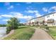 Backyard view of townhomes along a lake with a bench near a paved path at 816 Lilyquist Way, Wake Forest, NC 27587