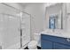 Modern bathroom featuring a glass-enclosed shower, black and white tiled floor and a blue vanity with a white countertop at 816 Lilyquist Way, Wake Forest, NC 27587