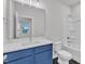 Bathroom with blue vanity with a quartz countertop, toilet, and tub-shower combo at 816 Lilyquist Way, Wake Forest, NC 27587