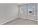 Bedroom with neutral walls, carpet and two windows overlooking the neighborhood at 816 Lilyquist Way, Wake Forest, NC 27587