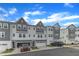 Well-maintained townhomes featuring attached two-car garages, a gray facade, and beautiful landscaping at 816 Lilyquist Way, Wake Forest, NC 27587