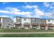 Back view of gray and white townhomes with wooden decks, lawn, and sidewalk at 816 Lilyquist Way, Wake Forest, NC 27587