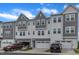 Well-maintained townhomes featuring attached two-car garages, a gray facade, and beautiful landscaping at 816 Lilyquist Way, Wake Forest, NC 27587