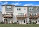 Rear exterior of gray and white townhomes with wooden decks and grassy lawn at 816 Lilyquist Way, Wake Forest, NC 27587