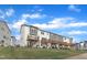 Exterior of townhomes with rear decks, grassy lawn, and sidewalks on a sunny day at 816 Lilyquist Way, Wake Forest, NC 27587