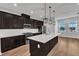 Modern kitchen with dark wood cabinets, stainless steel appliances, a white countertop island, and pendant lighting at 816 Lilyquist Way, Wake Forest, NC 27587
